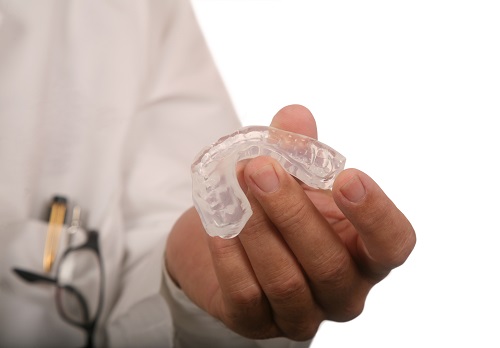 Dentist holding a mouth guard at Irvine Dentistry.