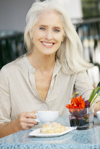 Senior woman enjoying her food and coffee.